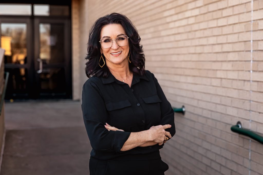 Woman smiling in front of college building